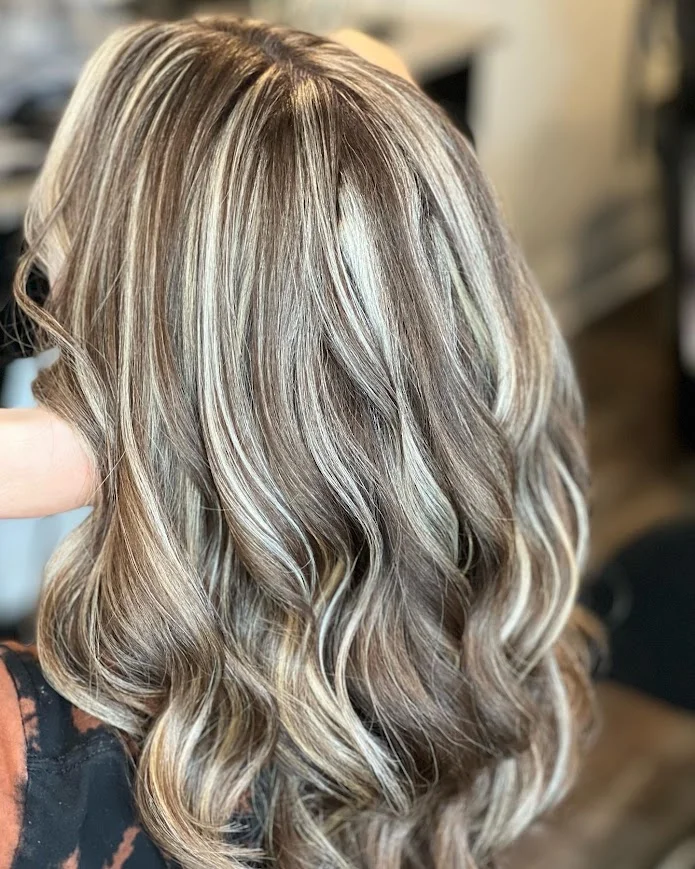 A vibrant image of a woman with stunning, Dimensional Blondes highlight exuding intensity and passion through her